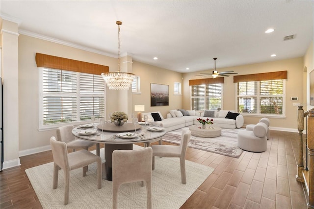 dining room featuring ceiling fan with notable chandelier and ornamental molding