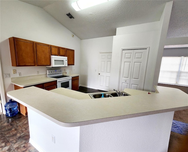 kitchen with lofted ceiling, sink, white appliances, and an island with sink