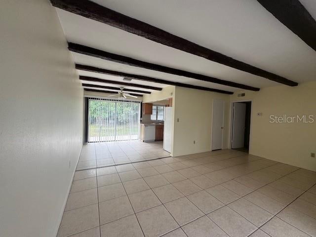 spare room featuring light tile patterned floors, ceiling fan, and beam ceiling