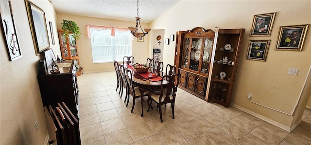 dining room featuring light tile patterned flooring, a textured ceiling, and a chandelier