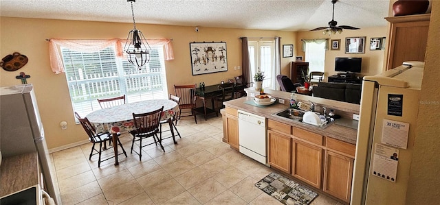 kitchen featuring refrigerator, ceiling fan with notable chandelier, sink, pendant lighting, and dishwasher