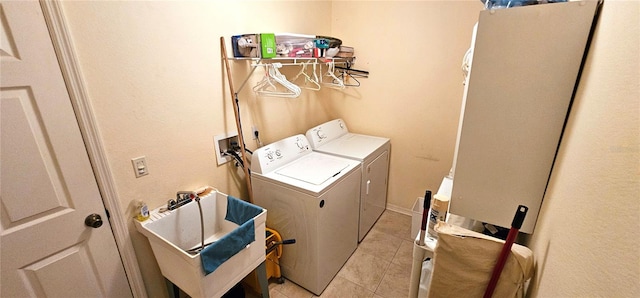 washroom with washing machine and dryer, light tile patterned floors, and sink