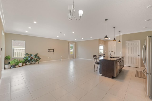 kitchen featuring appliances with stainless steel finishes, plenty of natural light, sink, and an island with sink