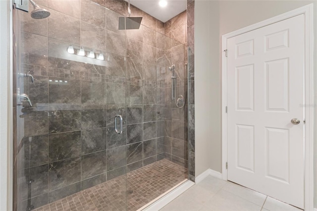 bathroom with an enclosed shower and tile patterned flooring