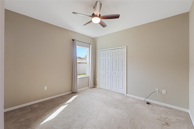 unfurnished bedroom featuring a closet, light colored carpet, and ceiling fan