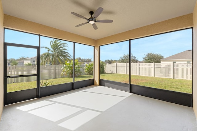 unfurnished sunroom with a wealth of natural light and ceiling fan