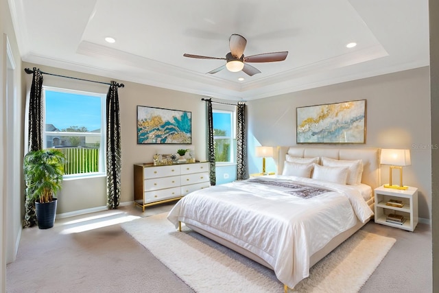 carpeted bedroom with multiple windows, crown molding, ceiling fan, and a raised ceiling