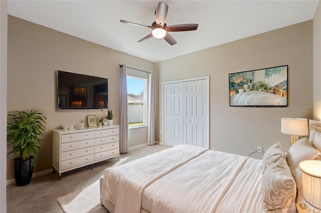 bedroom with light carpet, ceiling fan, and a closet