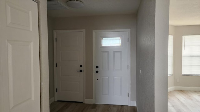 entryway featuring a wealth of natural light, baseboards, and wood finished floors