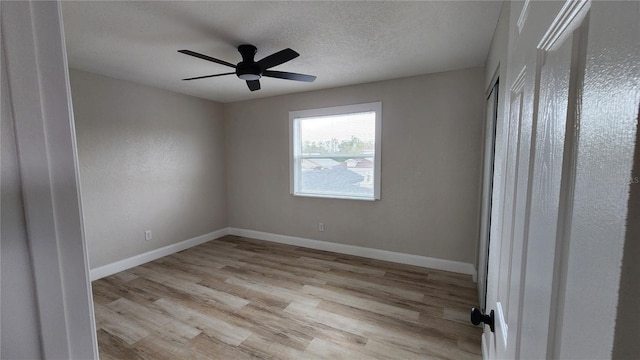 unfurnished room featuring light hardwood / wood-style floors, ceiling fan, and a textured ceiling