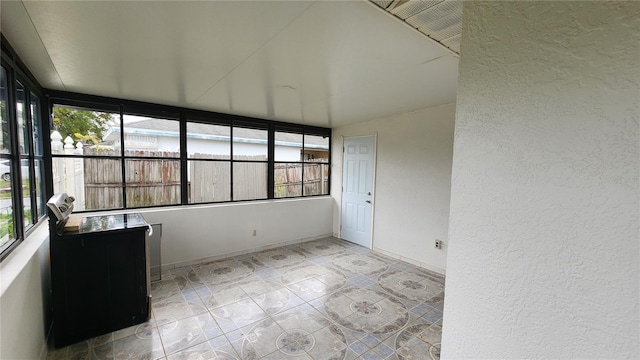 unfurnished sunroom with plenty of natural light and lofted ceiling