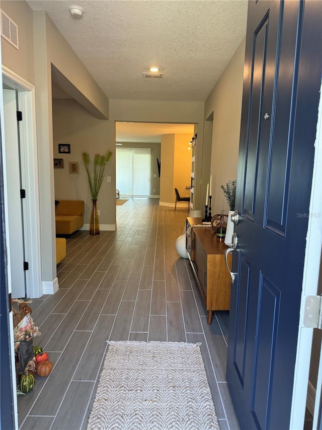 hallway featuring a textured ceiling and dark wood-type flooring