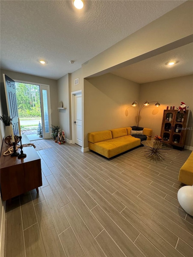 living room with hardwood / wood-style floors and a textured ceiling