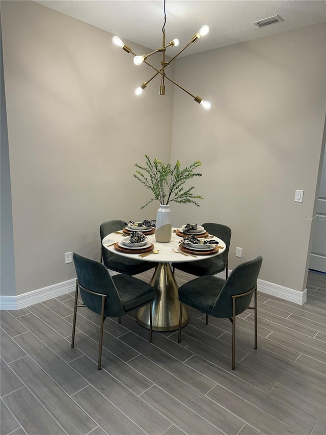 dining area featuring a chandelier and wood-type flooring