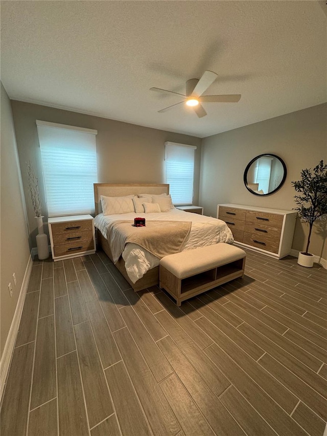 bedroom featuring multiple windows, ceiling fan, dark hardwood / wood-style flooring, and a textured ceiling