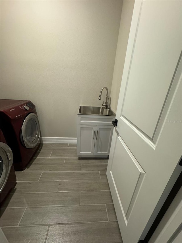 washroom featuring washer / clothes dryer, sink, and cabinets