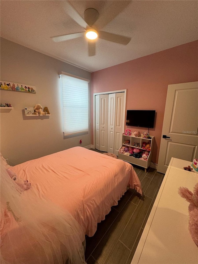 bedroom featuring ceiling fan, a closet, and dark wood-type flooring