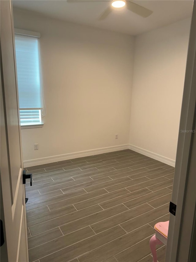 spare room featuring ceiling fan and dark wood-type flooring