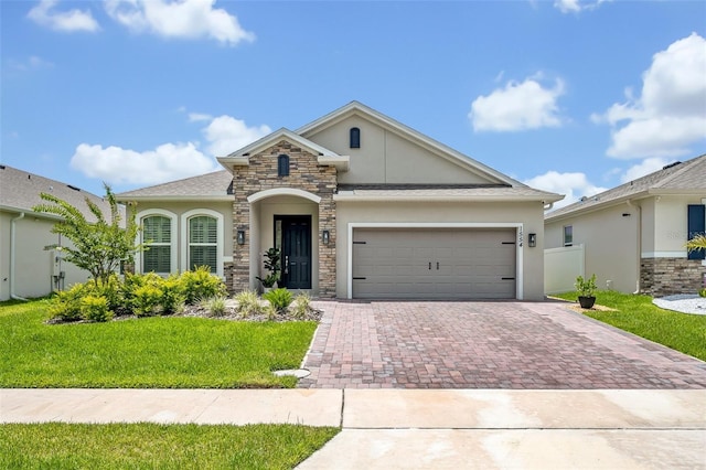 1554 Outback Rd W, Saint Cloud, FL 34771 - view of front of property featuring decorative driveway, stucco siding, stone siding, and an attached garage