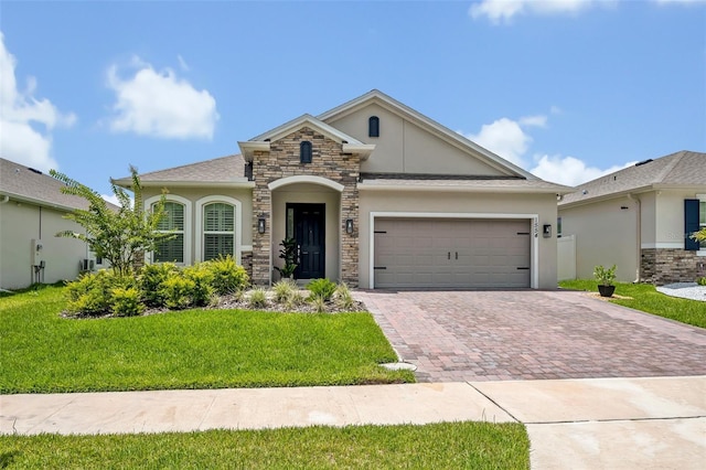 1554 Outback Rd W, Saint Cloud, FL 34771 - view of front of home with stucco siding, decorative driveway, an attached garage, a front yard, and stone siding