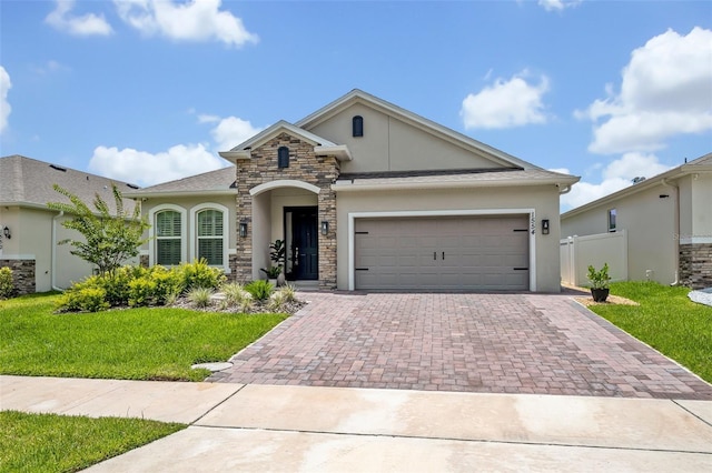 1554 Outback Rd W, Saint Cloud, FL 34771 - view of front of property featuring stucco siding, decorative driveway, stone siding, and a garage