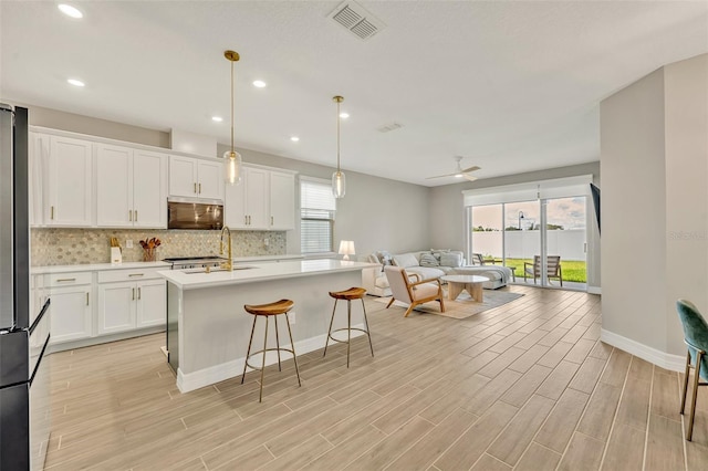 1554 Outback Rd W, Saint Cloud, FL 34771 - kitchen featuring open floor plan, tasteful backsplash, light countertops, white cabinetry, and recessed lighting