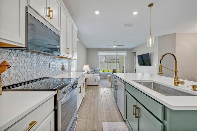 1554 Outback Rd W, Saint Cloud, FL 34771 - kitchen with appliances with stainless steel finishes, green cabinetry, white cabinets, backsplash, and open floor plan