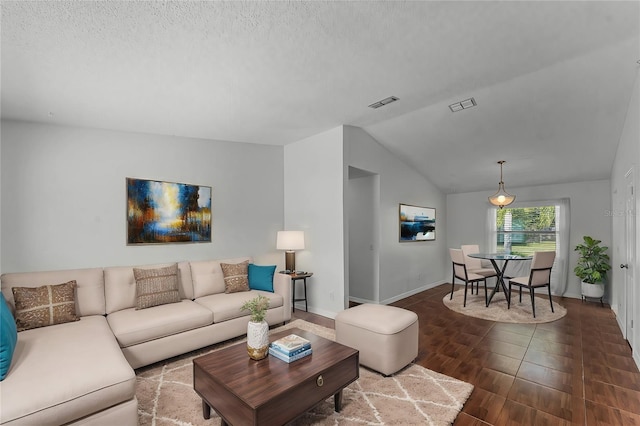 living room with dark wood-type flooring, lofted ceiling, and a textured ceiling