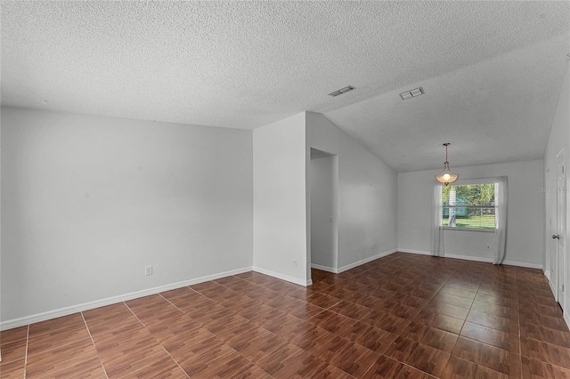 interior space with a textured ceiling and vaulted ceiling