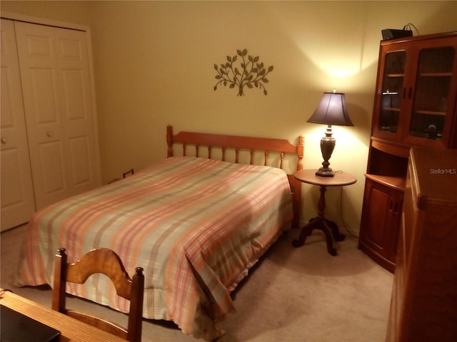 bedroom featuring light carpet and a closet