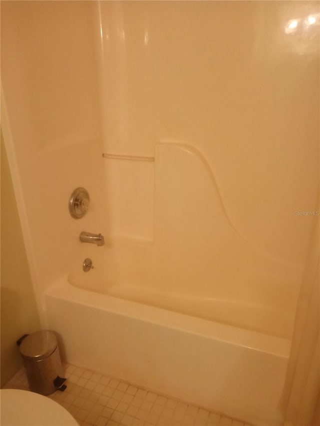 bathroom with tile patterned floors,  shower combination, and toilet