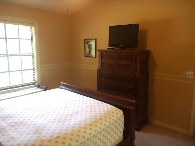 carpeted bedroom with vaulted ceiling