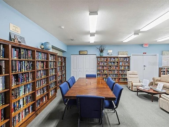 dining area with carpet and a textured ceiling