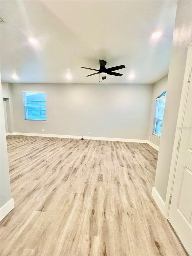 unfurnished room featuring light wood-type flooring, plenty of natural light, and ceiling fan