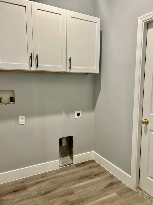 clothes washing area with hookup for an electric dryer, hookup for a washing machine, cabinets, and light hardwood / wood-style floors