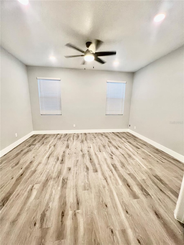 empty room featuring ceiling fan, light hardwood / wood-style floors, and a textured ceiling