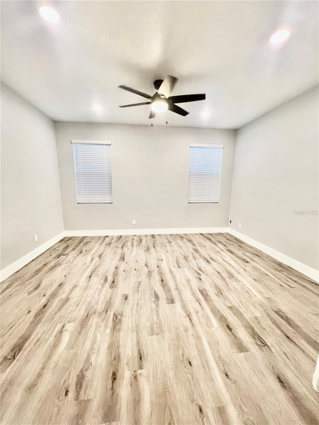 empty room with ceiling fan and light hardwood / wood-style floors