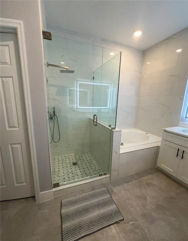 bathroom with vanity and independent shower and bath