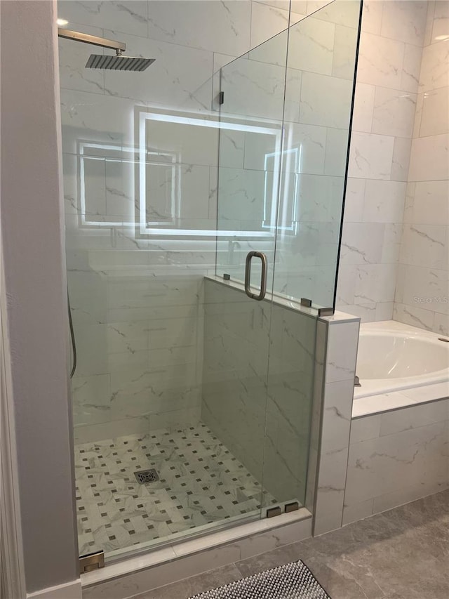 bathroom featuring shower with separate bathtub