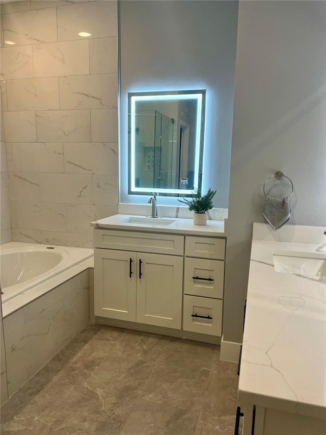 bathroom with vanity and tiled tub