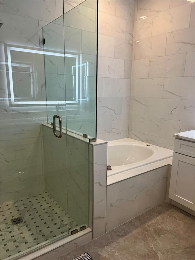 bathroom with vanity and shower with separate bathtub