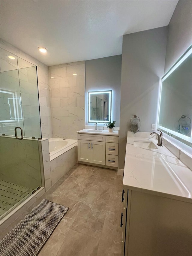 bathroom with vanity and shower with separate bathtub