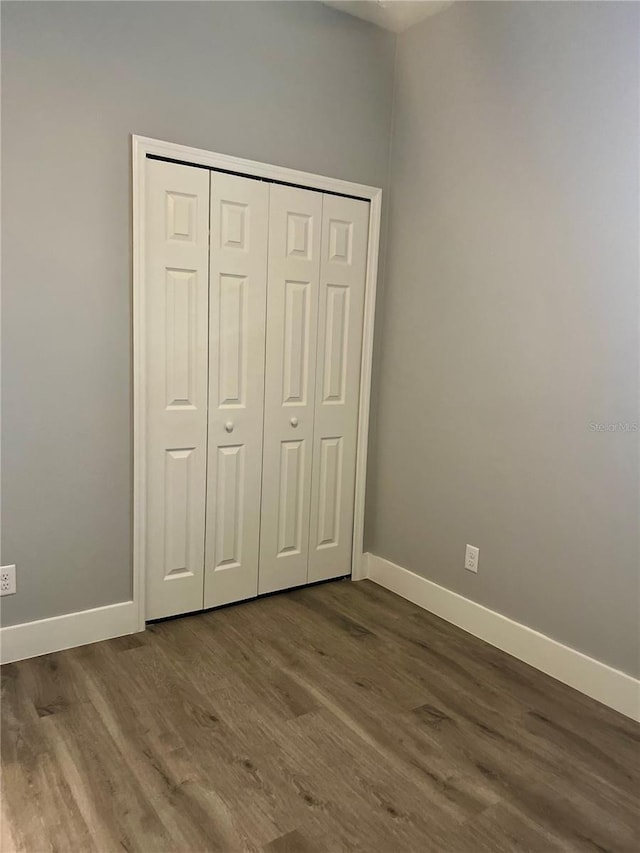 unfurnished bedroom featuring hardwood / wood-style floors and a closet