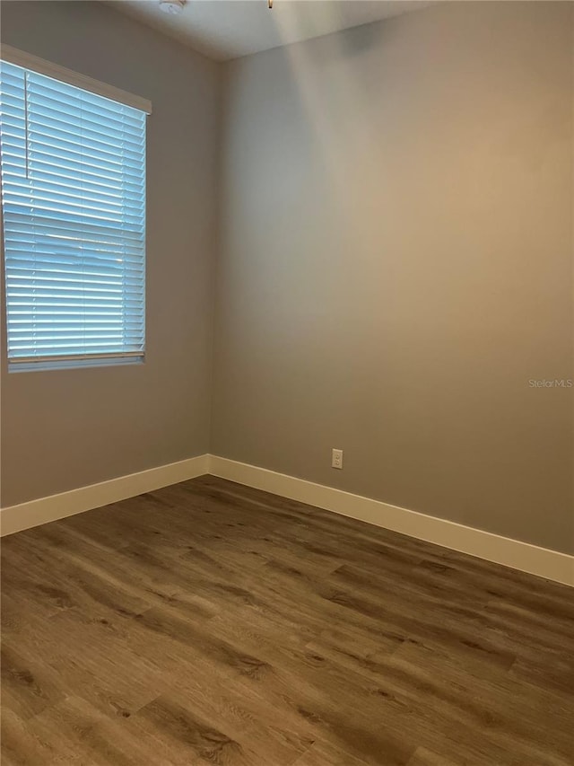 empty room with hardwood / wood-style flooring and plenty of natural light