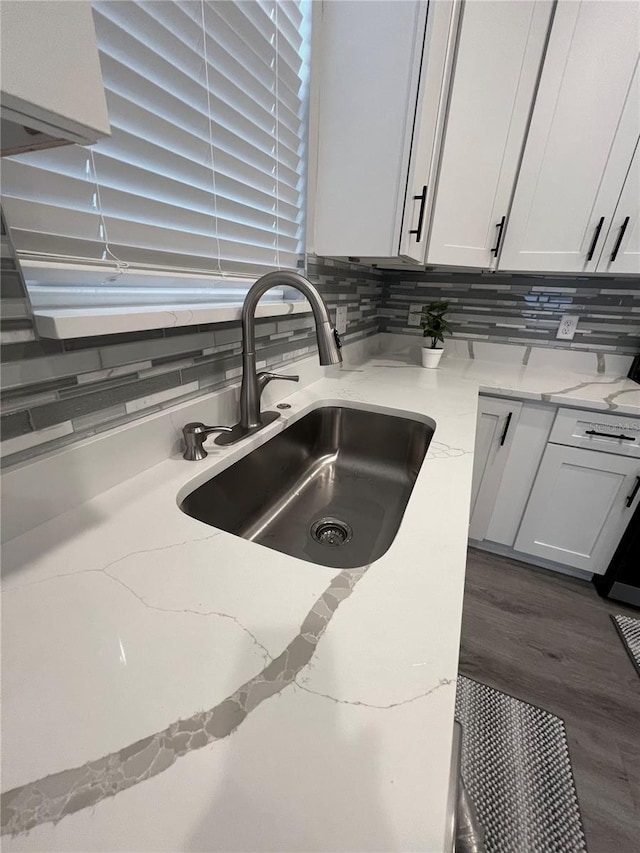 details featuring light stone countertops, sink, dark hardwood / wood-style flooring, decorative backsplash, and white cabinets