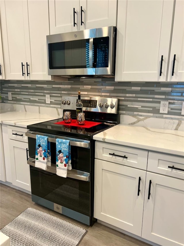 kitchen with white cabinetry, light hardwood / wood-style floors, and appliances with stainless steel finishes