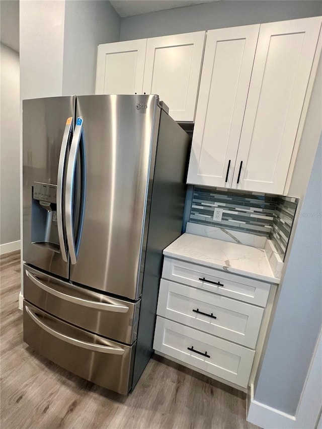 kitchen featuring hardwood / wood-style floors, white cabinetry, and stainless steel refrigerator with ice dispenser