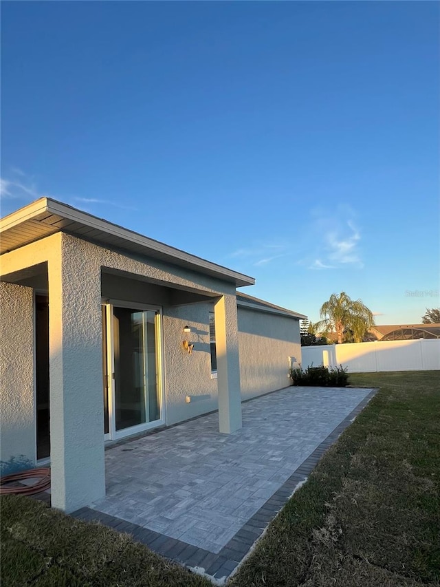 view of side of property with a patio area and a yard