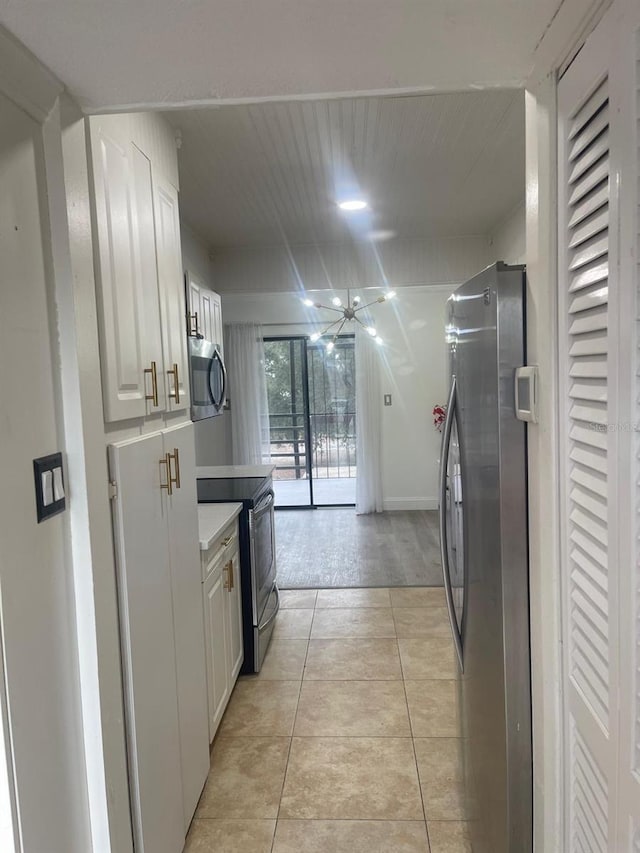 kitchen featuring white cabinets, light tile patterned floors, and stainless steel appliances