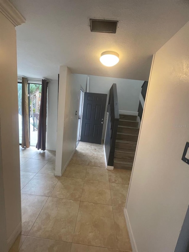 tiled entrance foyer featuring a textured ceiling